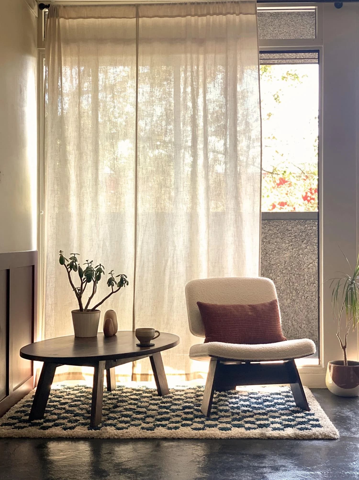 A counselling room with a chair, table, soft curtains, and warm natural light